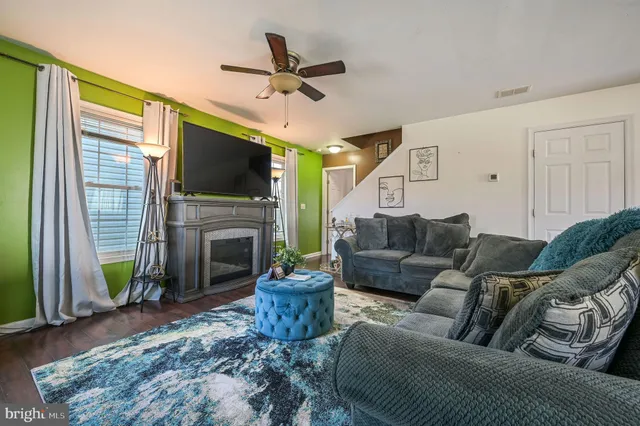 a living room with furniture a flat screen tv and a fireplace