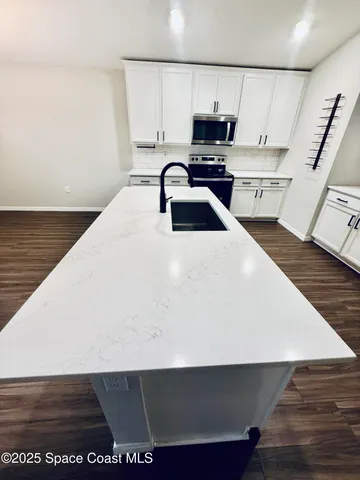 a kitchen with a sink a stove and cabinets
