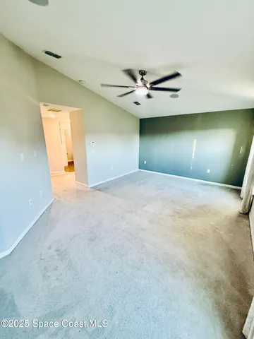 a view of an empty room with a ceiling fan