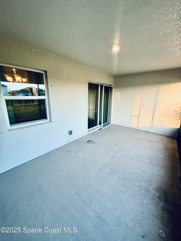 a view of an empty room with window and fireplace