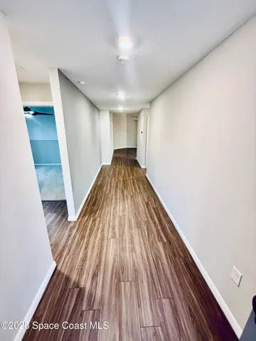 a view of hallway with wooden floor