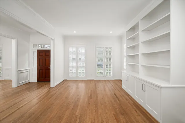 a view of an empty room with a window and wooden floor