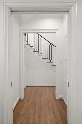 a view of a hallway with wooden floor and entryway
