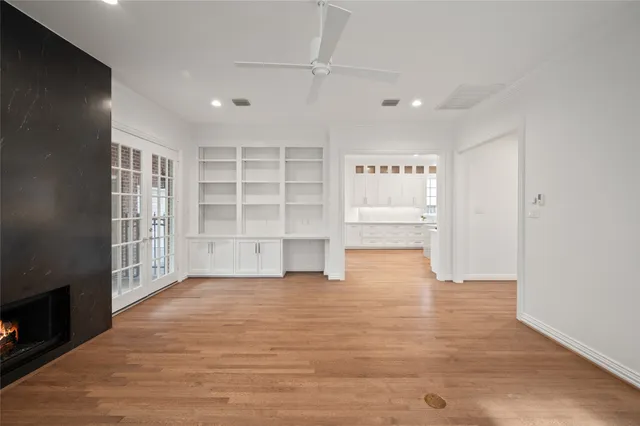 an empty room with cabinet and windows