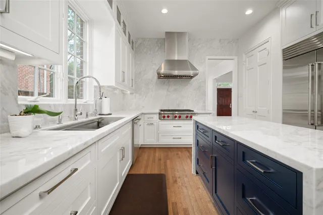 a large kitchen with stainless steel appliances lots of counter space and a sink