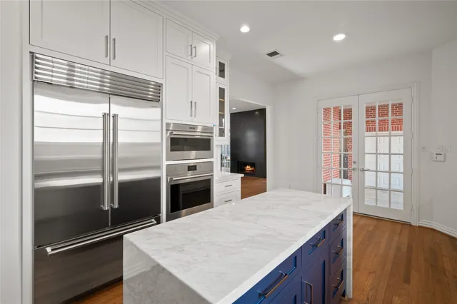 a kitchen with kitchen island a counter top space cabinets and stainless steel appliances