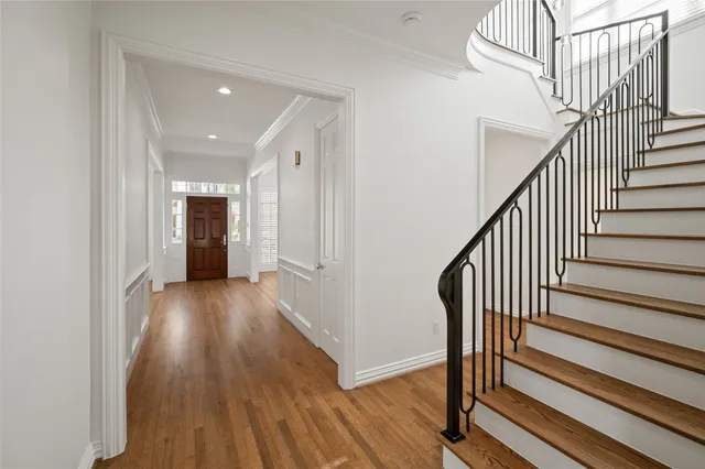 a view of a hallway with wooden floor and staircase