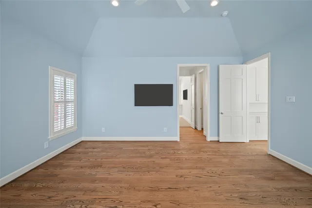 a view of a livingroom with wooden floor and a large window
