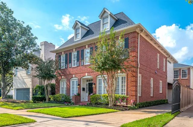 a front view of a house with yard and green space