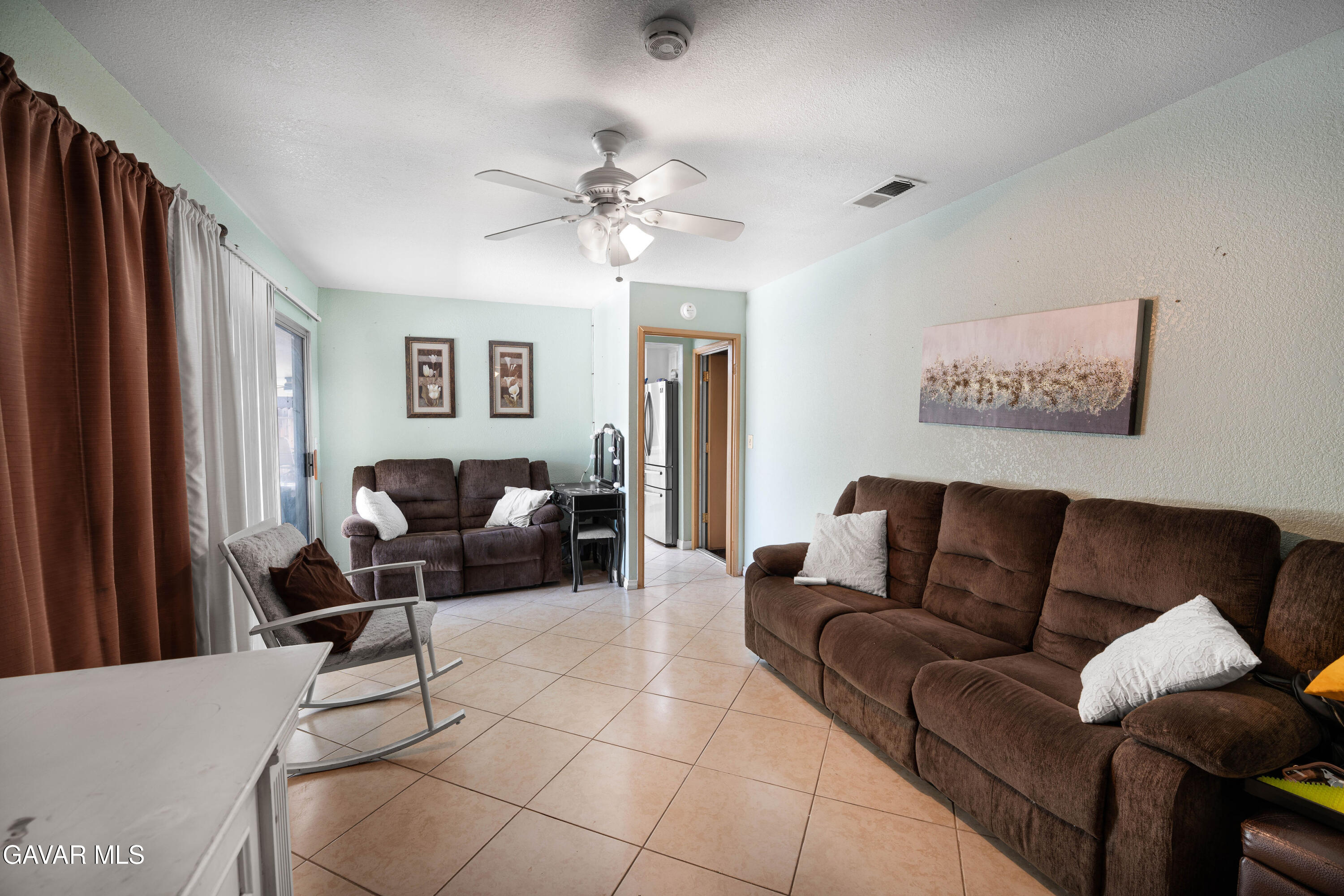 5009 East Ave R 11 Palmdale, CA 93552 - Photo 13 of 23 a living room with furniture and a flat screen tv