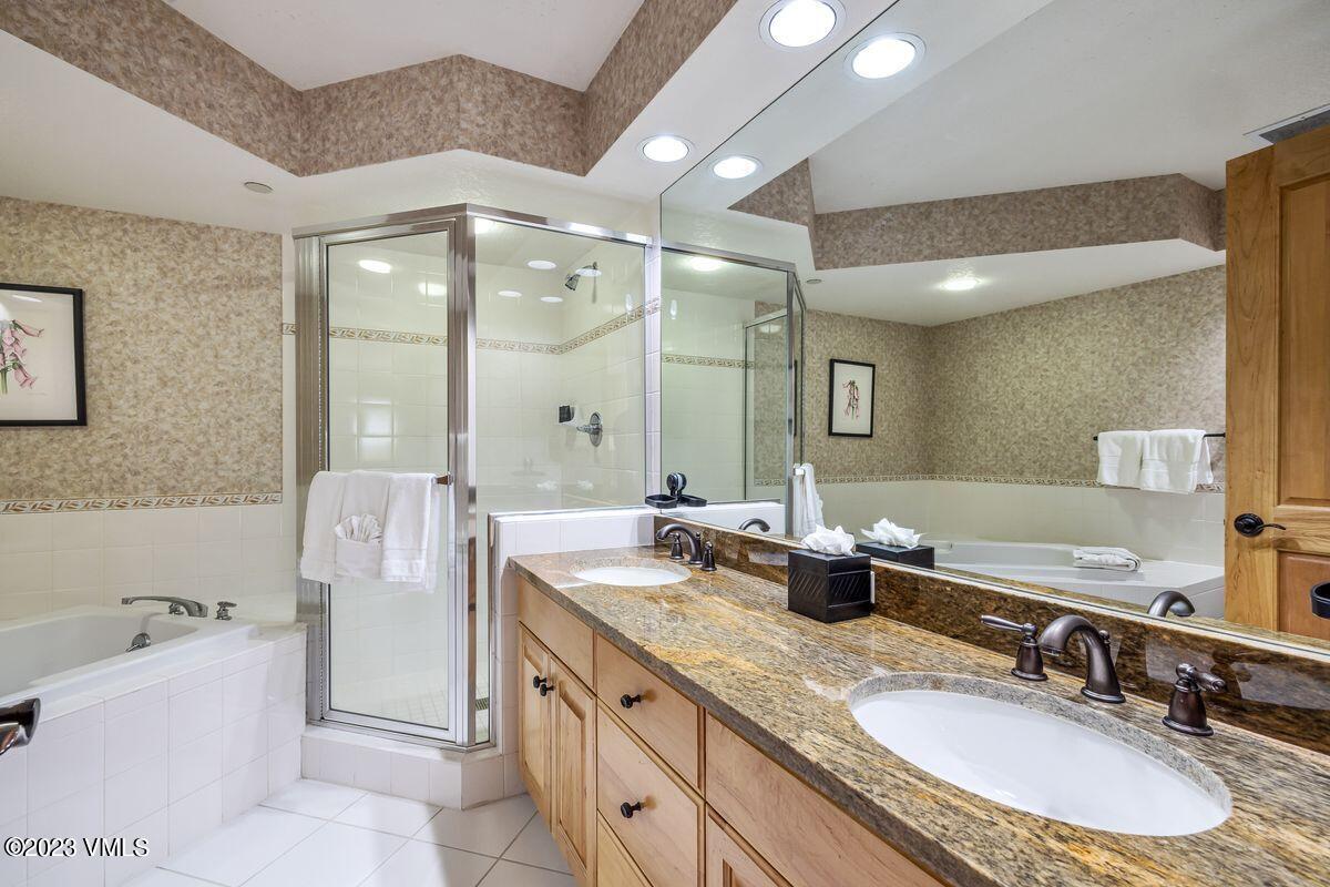 210 Offerson Road, Unit R225 Beaver Creek, CO 81620 - Photo 14 of 42 a bathroom with a granite countertop double vanity sink a mirror and a bathtub