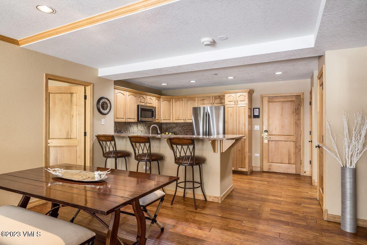 210 Offerson Road, Unit R225 Beaver Creek, CO 81620 - Photo 7 of 42 a dining room with furniture and wooden floor
