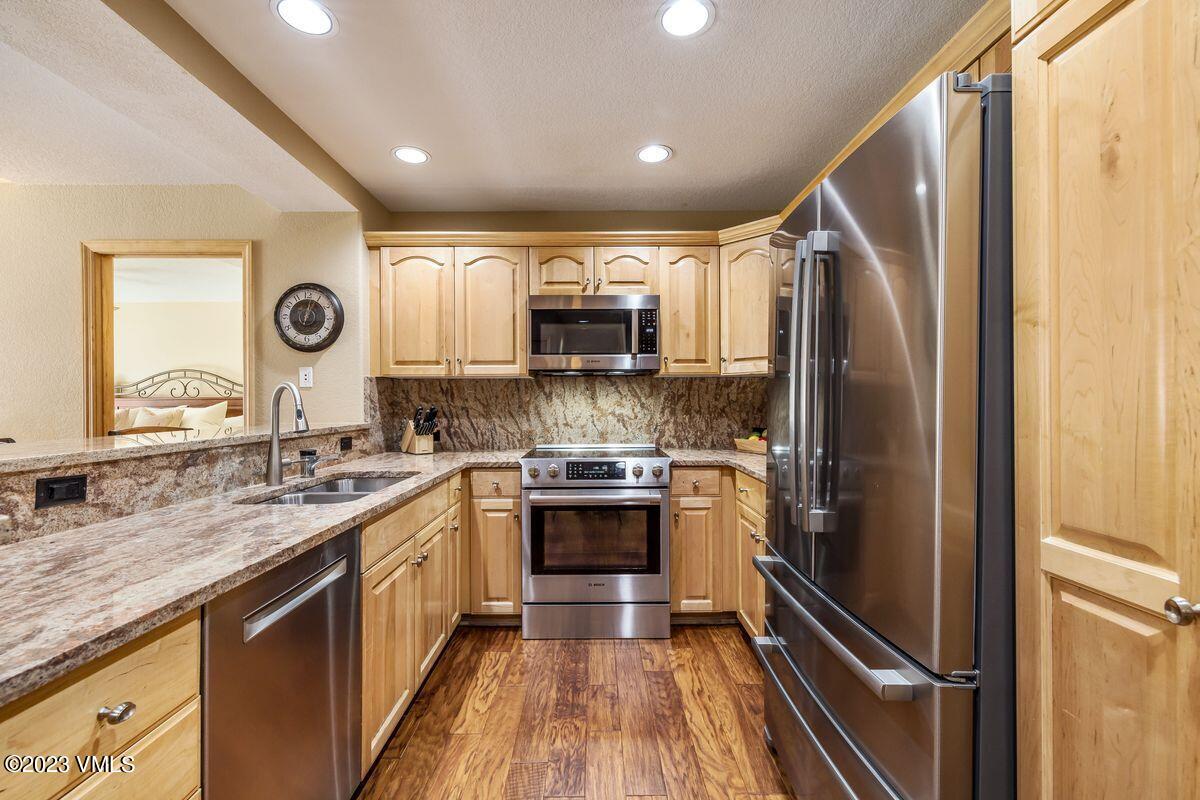 210 Offerson Road, Unit R225 Beaver Creek, CO 81620 - Photo 9 of 42 a kitchen with stainless steel appliances granite countertop a refrigerator and a sink