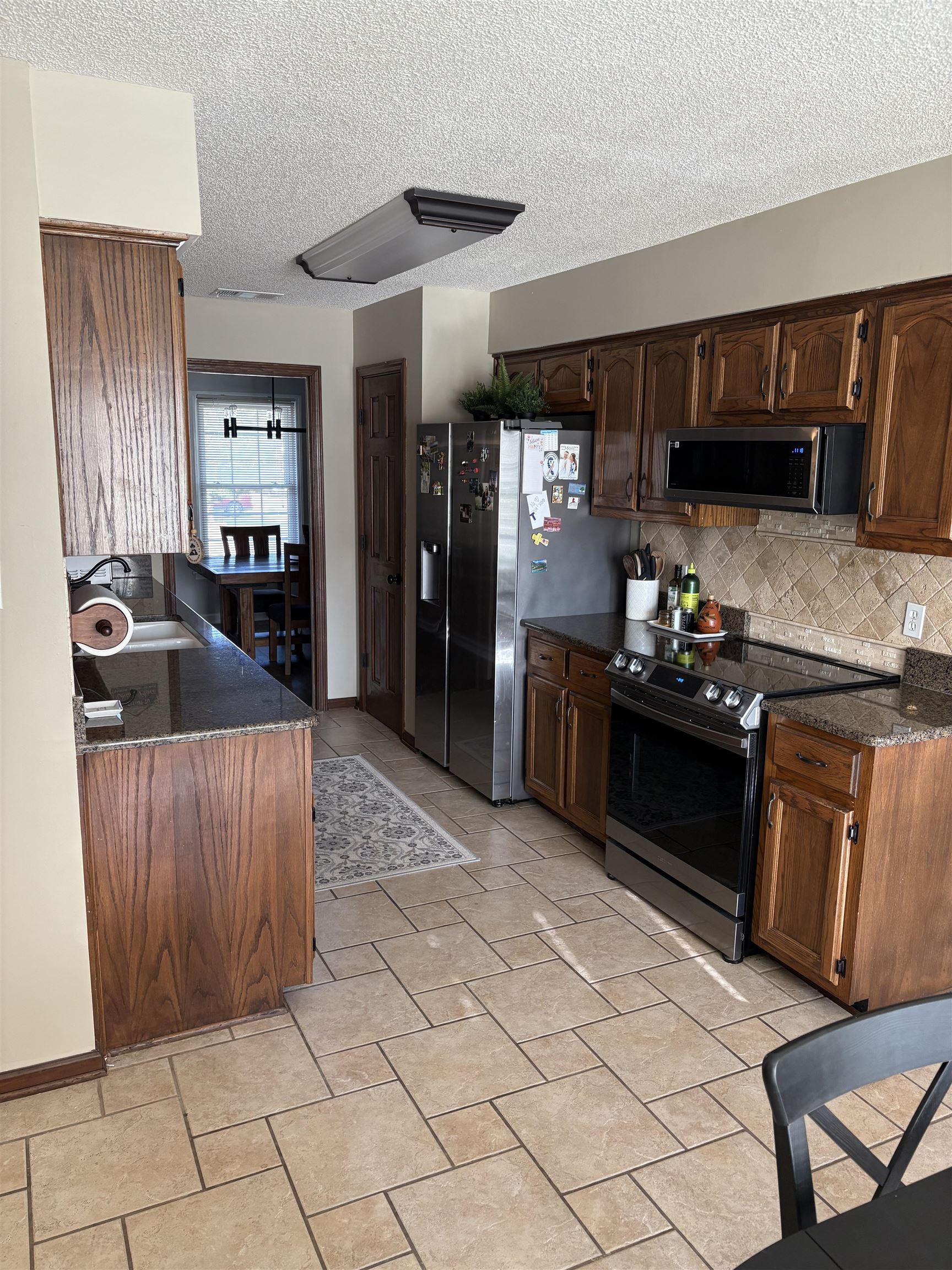 488 Old Collierville Arlington Road Collierville, TN 38017 - Photo 7 of 23 a kitchen with granite countertop a stove and a refrigerator
