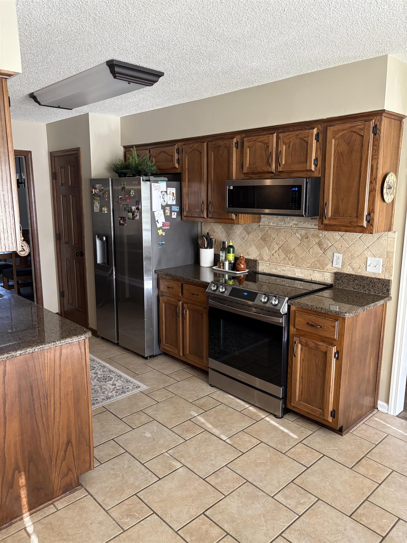 488 Old Collierville Arlington Road Collierville, TN 38017 - Photo 10 of 23 a kitchen with stainless steel appliances granite countertop a refrigerator and a stove