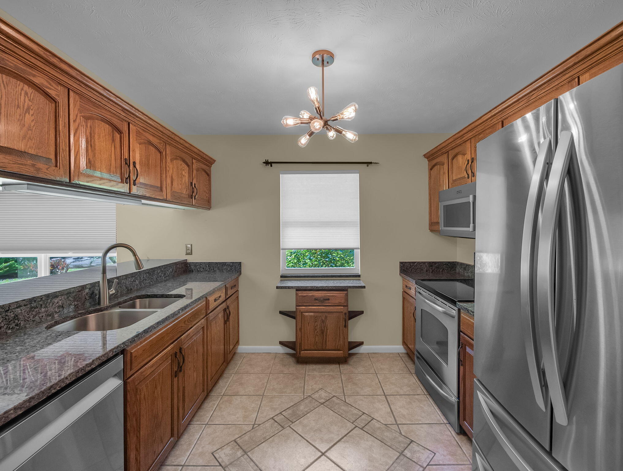 8165 Southeast Cypress Point Place Hobe Sound, FL 33455 - Photo 14 of 46 a kitchen with granite countertop a sink stainless steel appliances and a counter top space