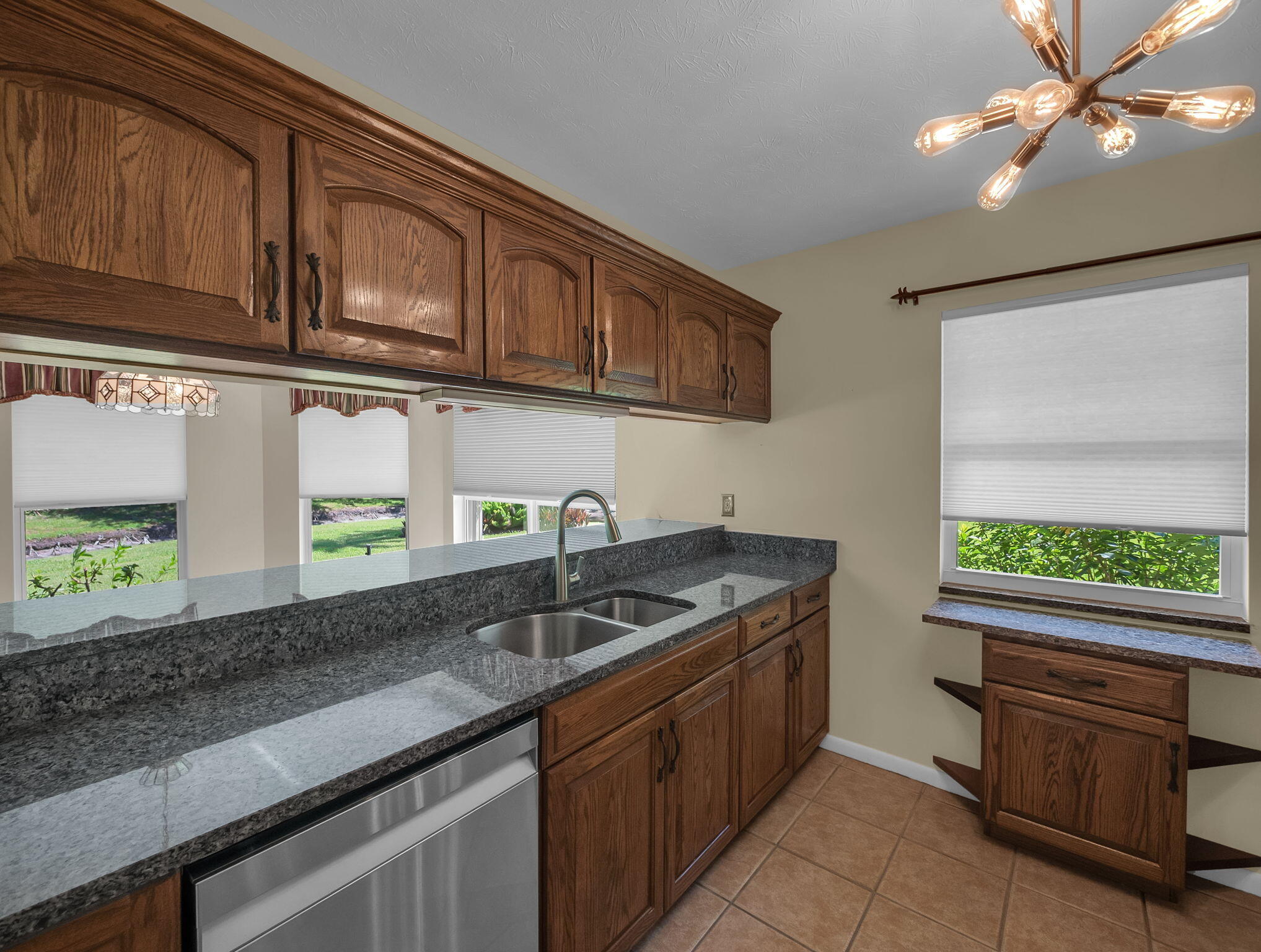 8165 Southeast Cypress Point Place Hobe Sound, FL 33455 - Photo 15 of 46 a kitchen with granite countertop stainless steel appliances a sink stove and cabinets