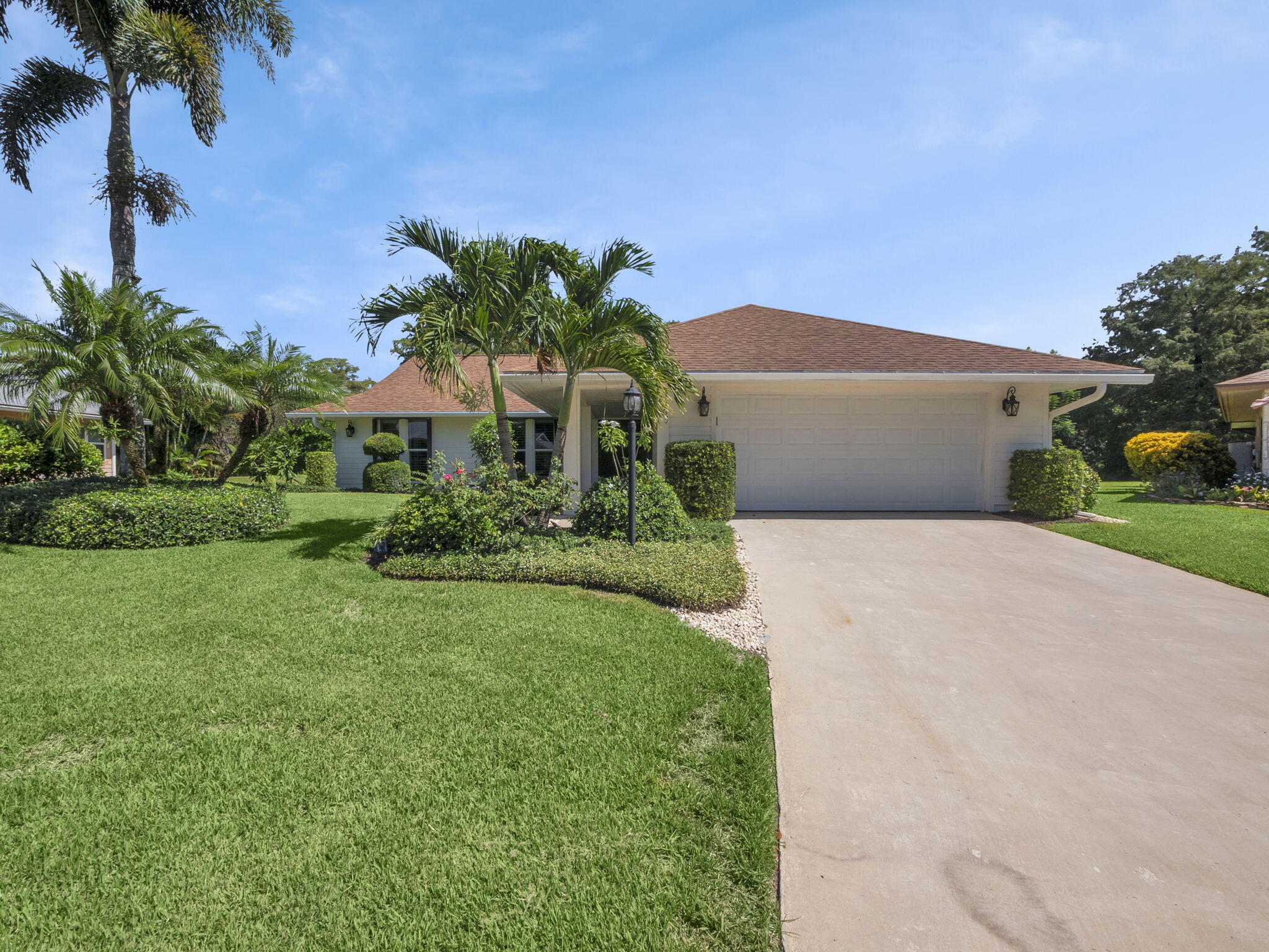 8165 Southeast Cypress Point Place Hobe Sound, FL 33455 - Photo 2 of 46 a front view of a house with garden