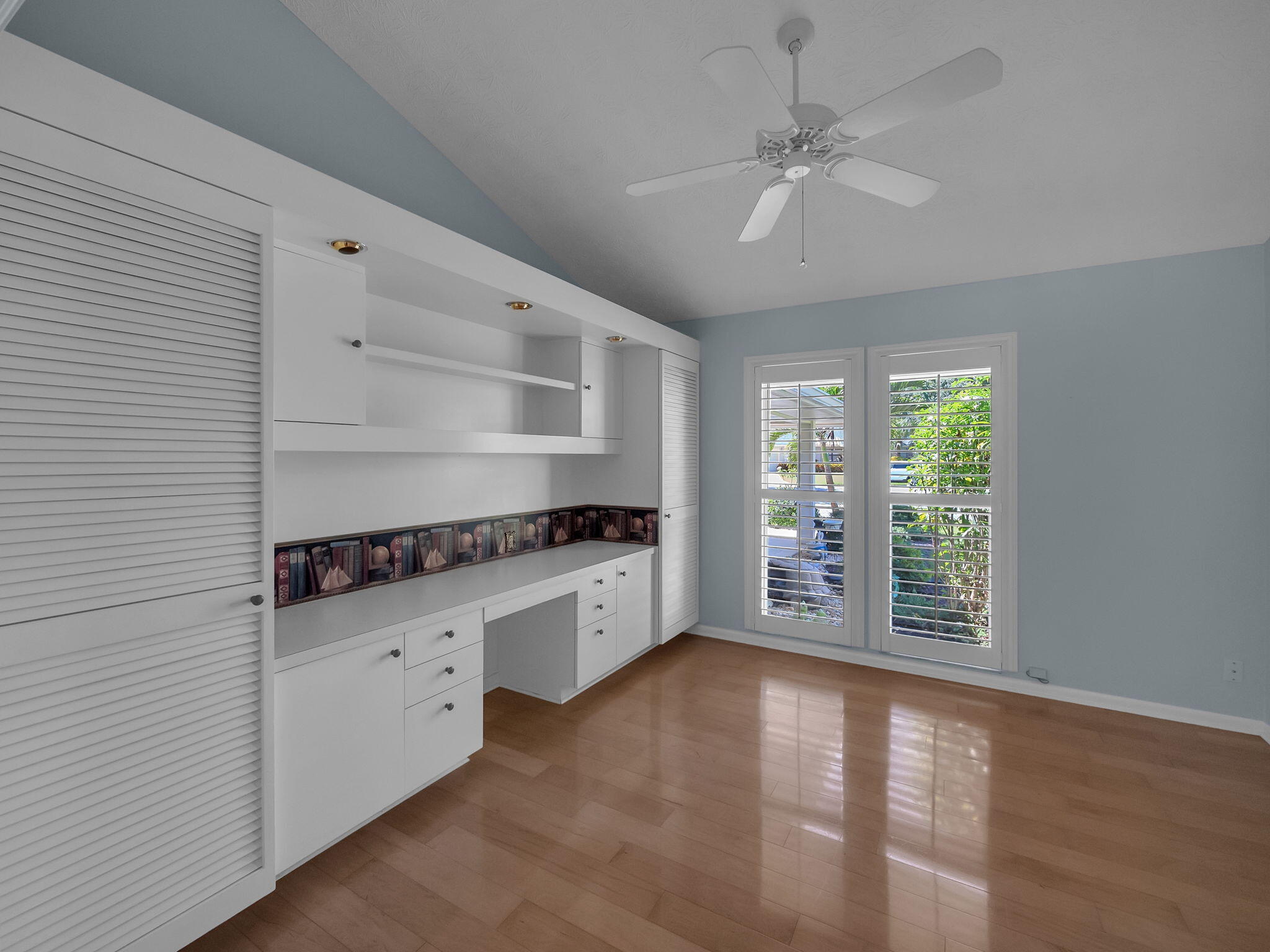 8165 Southeast Cypress Point Place Hobe Sound, FL 33455 - Photo 23 of 46 wooden floor in an empty room with a window and a kitchen view