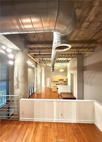a view of kitchen with stainless steel appliances granite countertop a refrigerator and a wooden cabinets