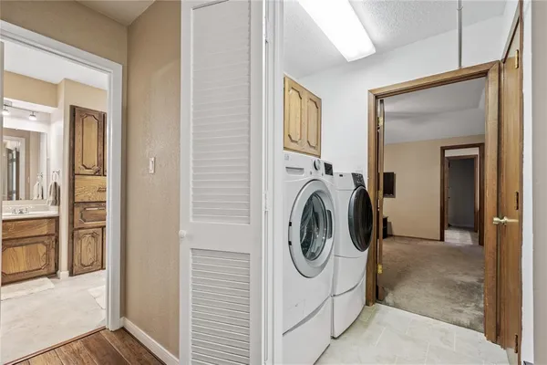 a kitchen with stainless steel appliances kitchen island granite countertop a refrigerator a sink dishwasher a stove and white countertops with wooden floor