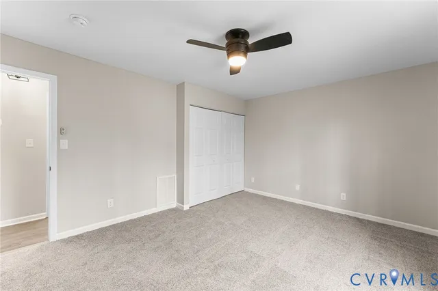 an empty room with a ceiling fan and a window