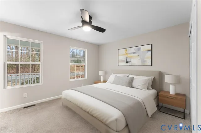 a bedroom with a large bed and two windows