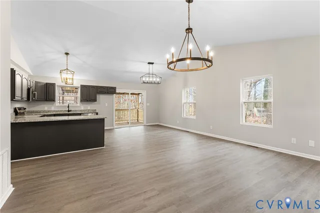 a view of kitchen with granite countertop stainless steel appliances cabinets a sink and a window