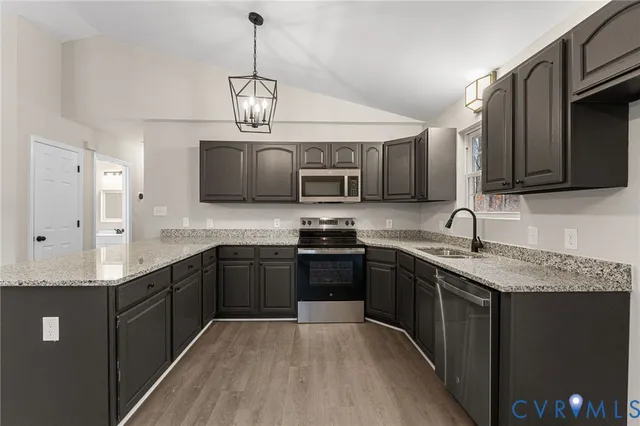 a kitchen with stainless steel appliances granite countertop a sink a stove top oven a counter space and cabinets