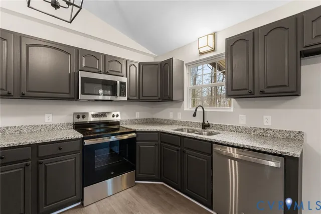 a kitchen with stainless steel appliances granite countertop a sink stove and microwave