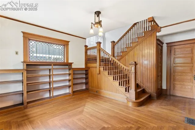 a view of a livingroom with furniture a chandelier and wooden floor