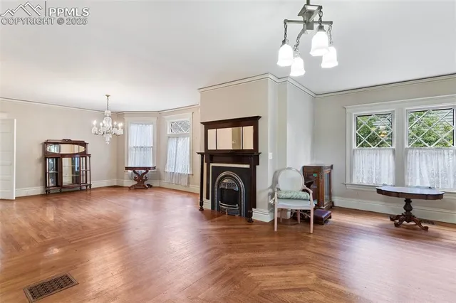 a view of a livingroom with wooden floor and a refrigerator