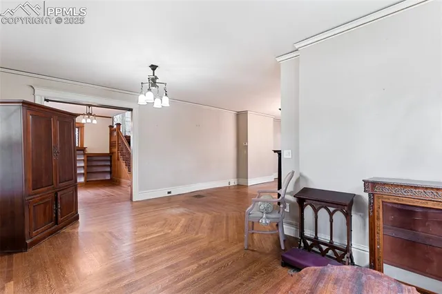 a view of a livingroom with a chandelier wooden floor and chandelier