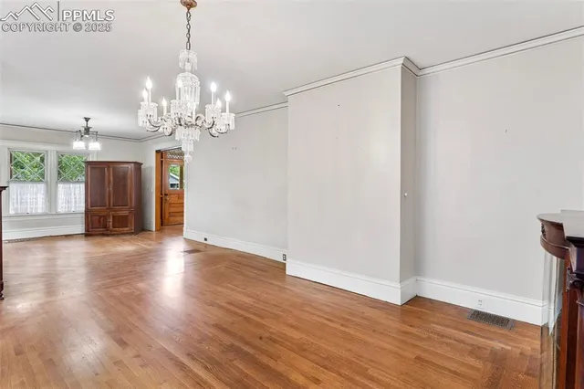 a kitchen with stainless steel appliances granite countertop a stove a sink and white cabinets with wooden floor