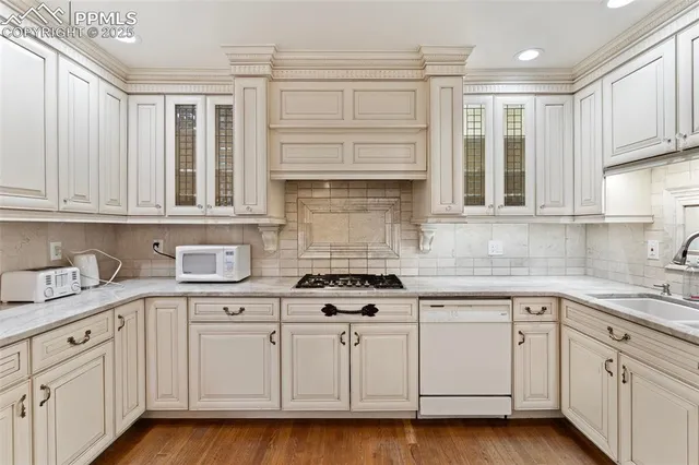 a kitchen with white cabinets and appliances
