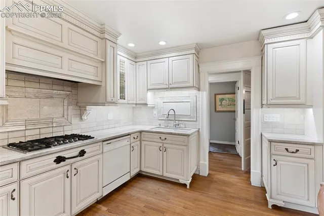 a kitchen with white cabinets and refrigerator