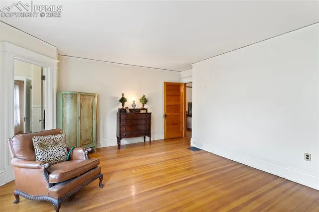 a view of a room with wooden floor and furniture