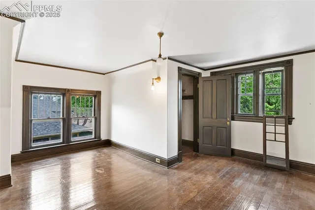a view of empty room with wooden floor