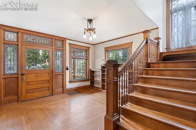 a view of entryway bedroom and hall with wooden floor