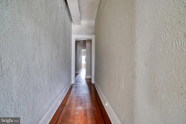 a view of a hallway with wooden floor and entryway