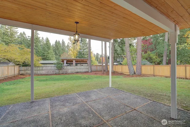 a view of a house with backyard and a tree