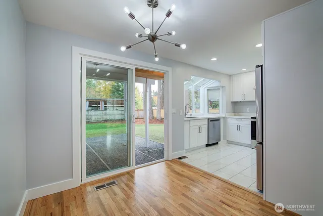 a kitchen with white cabinets stainless steel appliances and a window
