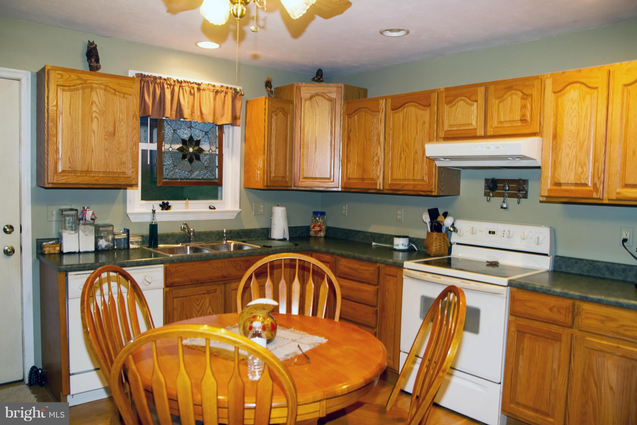 5249 Carroll Warehime Road Manchester, MD 21102 - Photo 12 of 26 a kitchen with granite countertop a stove a sink a dining table and chairs