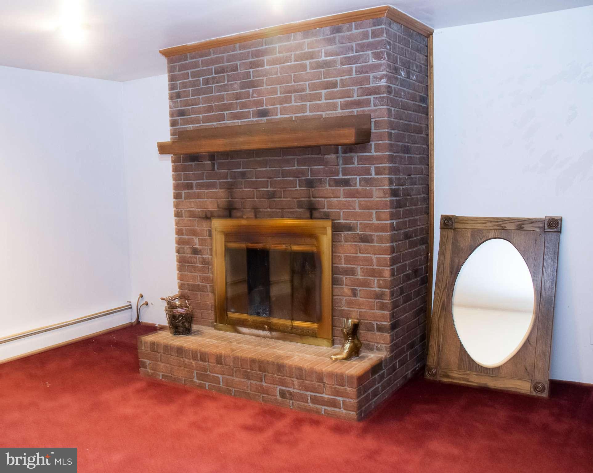 5249 Carroll Warehime Road Manchester, MD 21102 - Photo 25 of 26 a living room with a fireplace and a wooden floor
