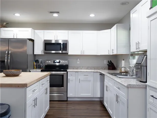 a kitchen with stainless steel appliances granite countertop a sink stove and refrigerator