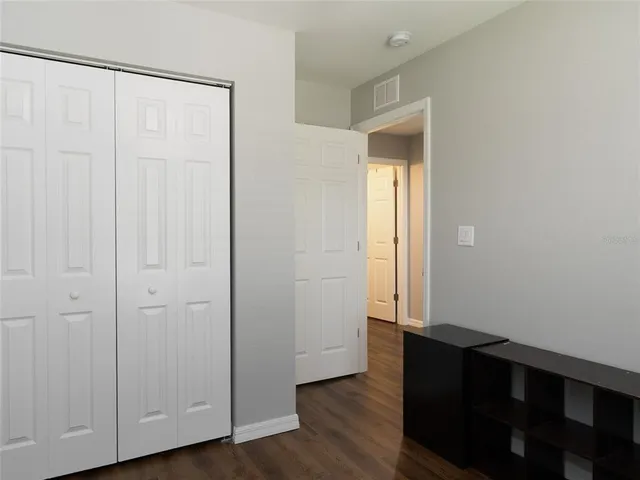 an empty room with wooden floor and closet