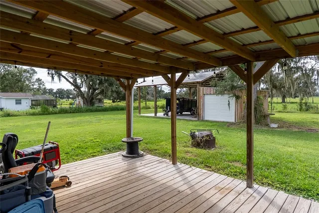 a view of a patio with wooden floor table and chairs