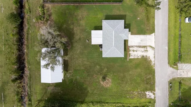 an aerial view of a house with a yard