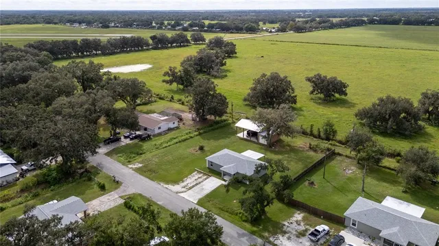 an aerial view of residential houses with outdoor space and lake view