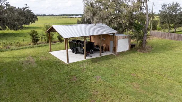 a view of a patio with table and chairs under an umbrella